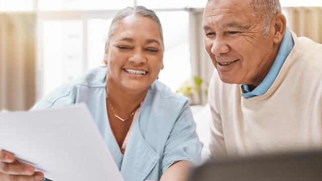 A man and his caregiver review a document. 