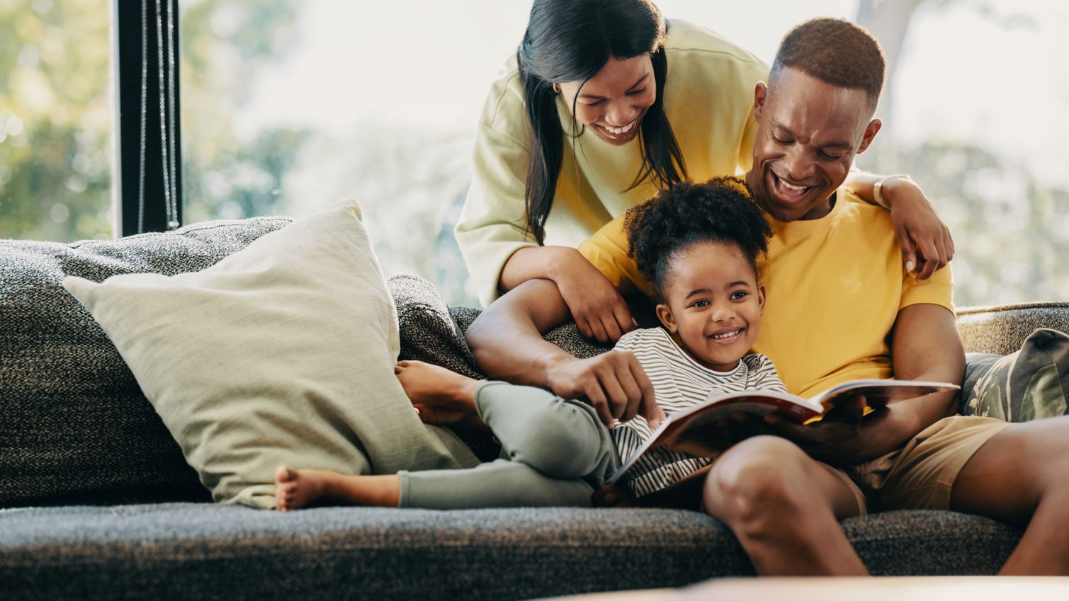 family sitting on a couch reading a magazine