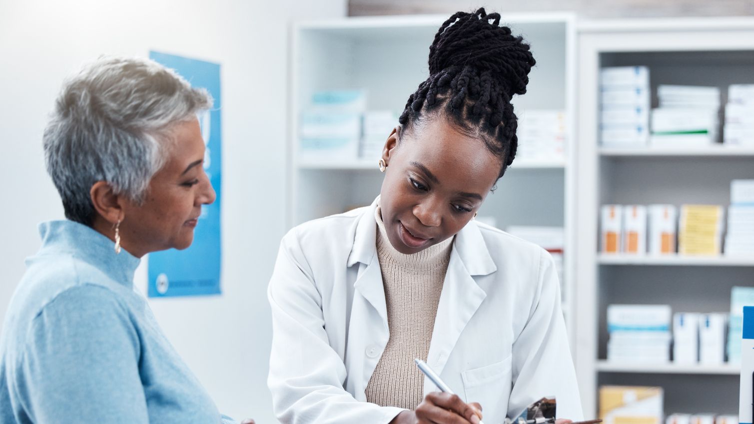 A pharmacist collects a signature from a patient. 