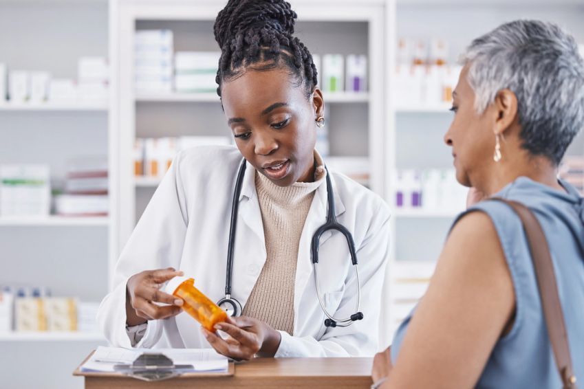 A pharmacist explains medicine directions to a patient. 