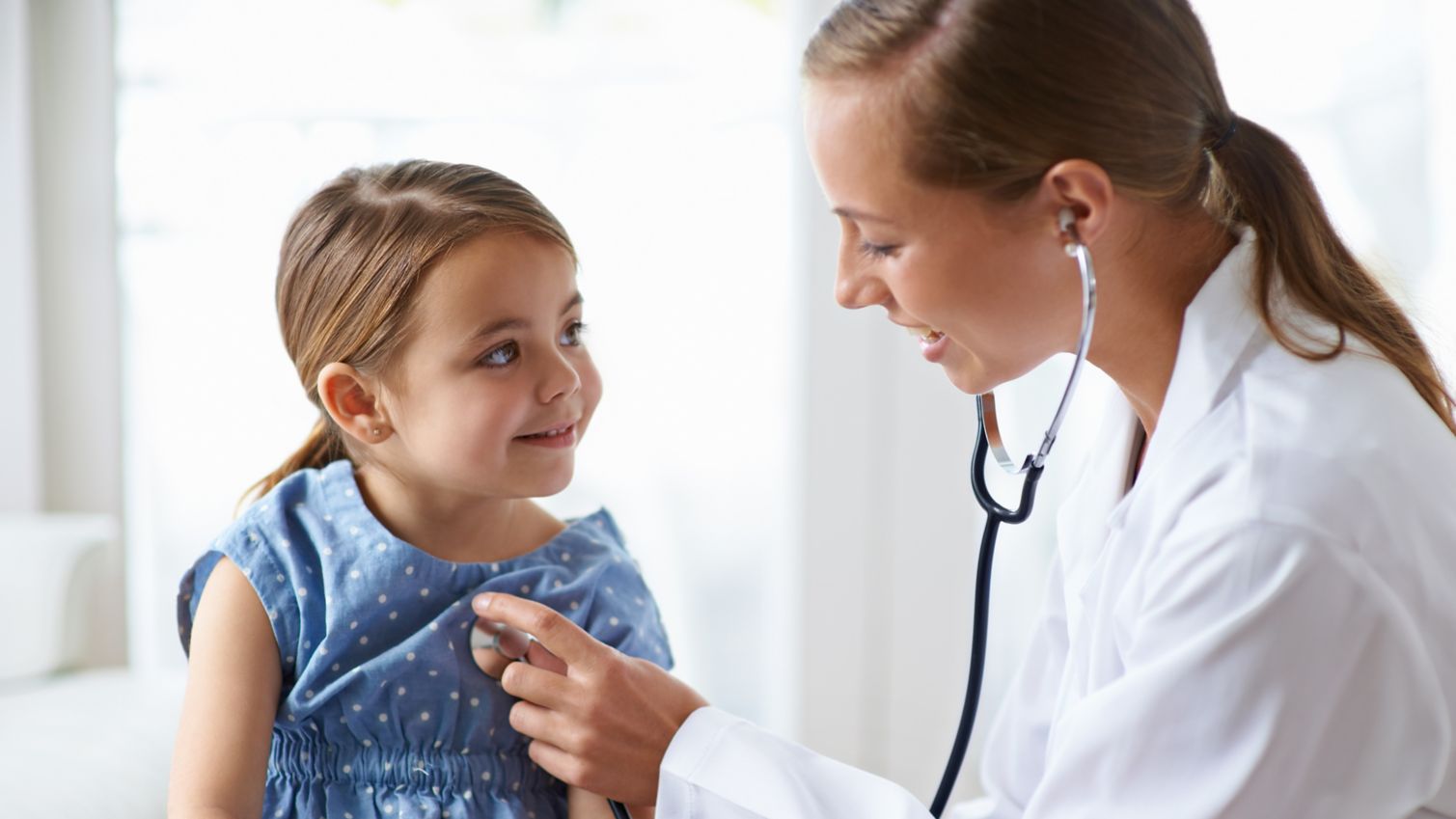 Young girl gets a checkup from the doctor.