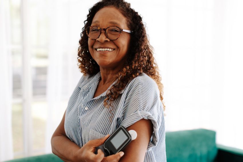 Senior woman using a flash glucose monitor to manage her diabetes at home