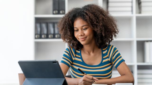 A woman looks up information on her laptop at home