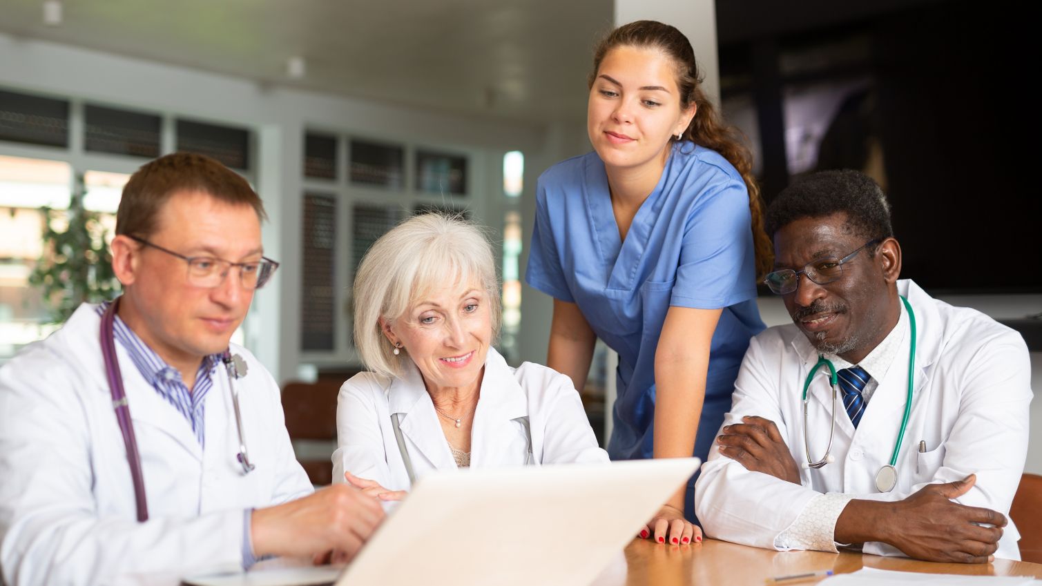 Group of medical professionals looking at a laptop