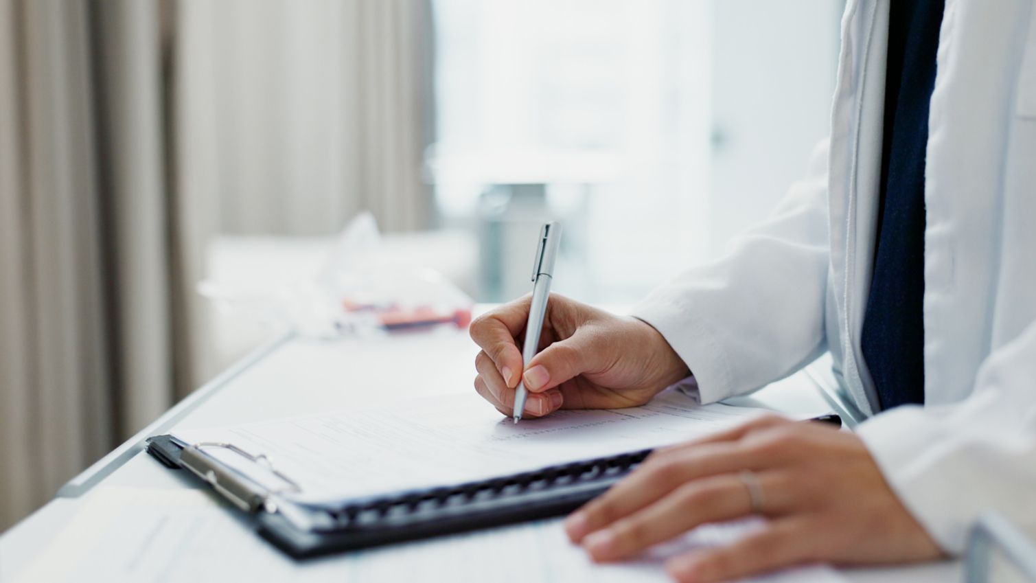 A male doctor filling out a medical form