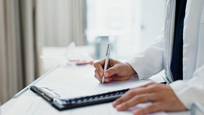 A male doctor filling out a medical form