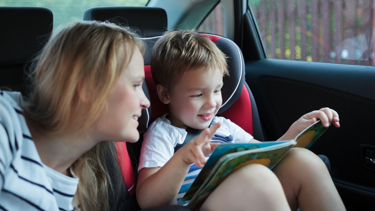 Child and adult looking at a book