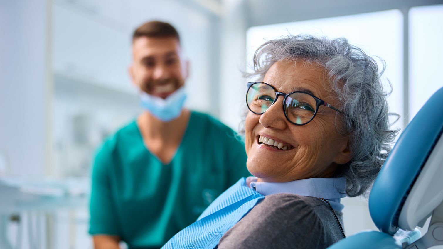 Satisfied senior woman at dentist's office looking at camera.