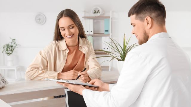 a dentist and a patient review a chart.