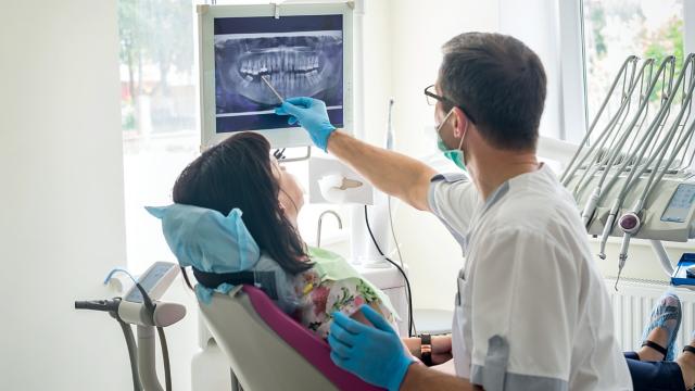 Dentist showing x-ray to female patient.