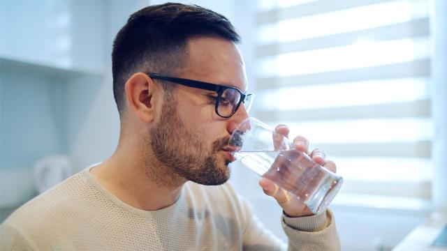 A man drinks a glass of water.