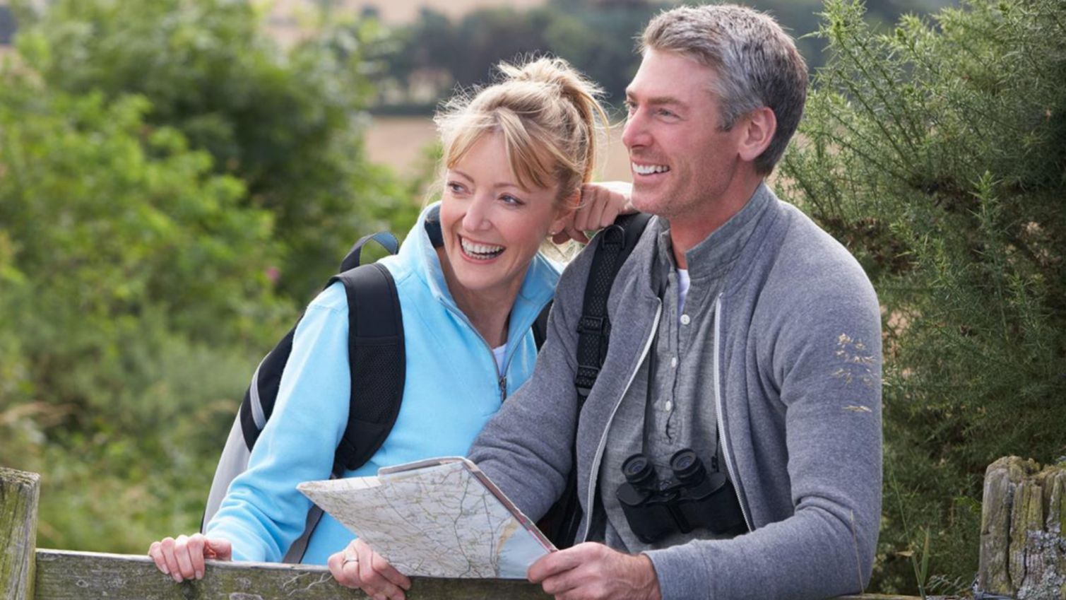 Man and woman outdoors with a map