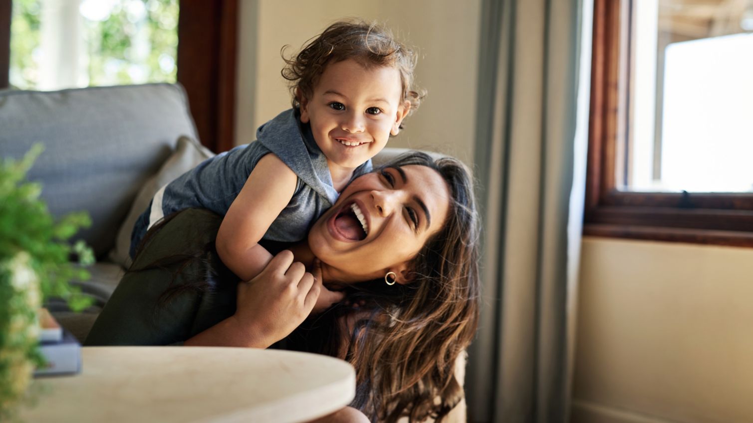 Toddler climbs on mom’s back