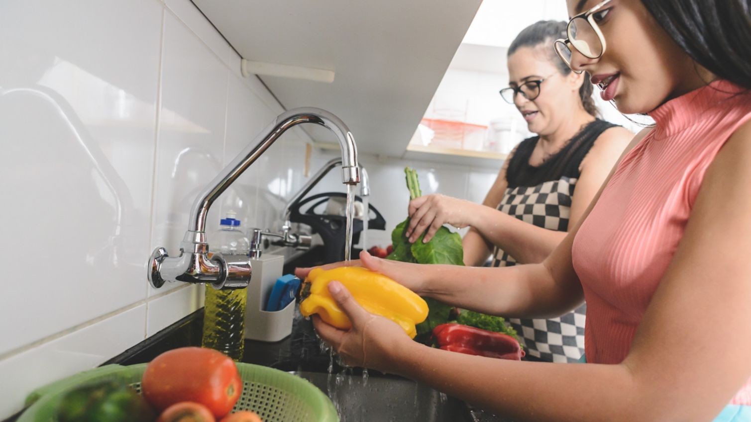 Mom and daughter preparing vegetables in kitchen