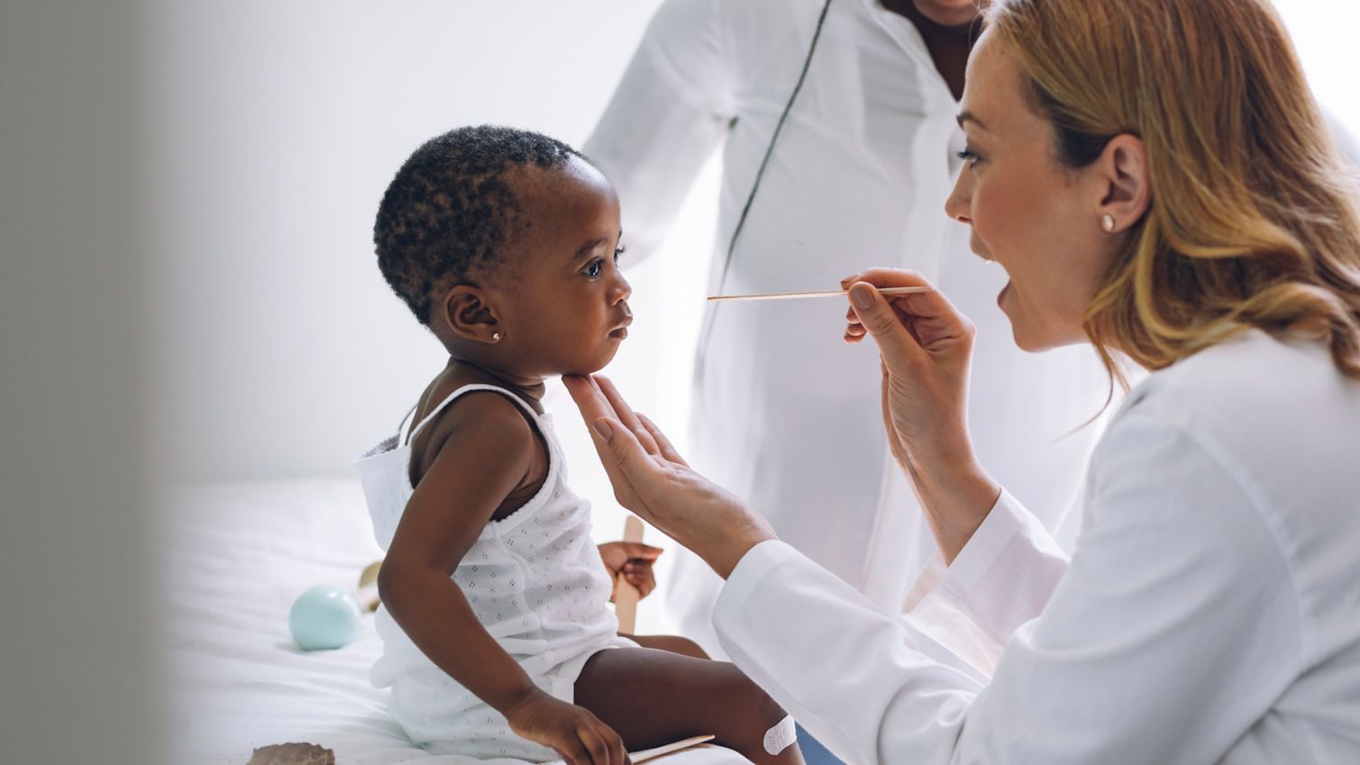 Provider examines baby while father watches