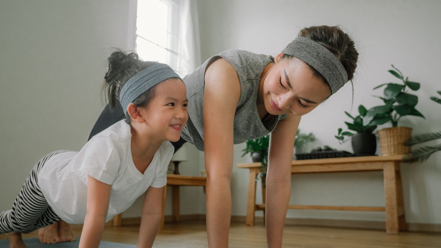 Mom and child doing mat exercises together.