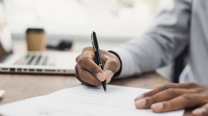 A male doctor takes notes on a patient's chart