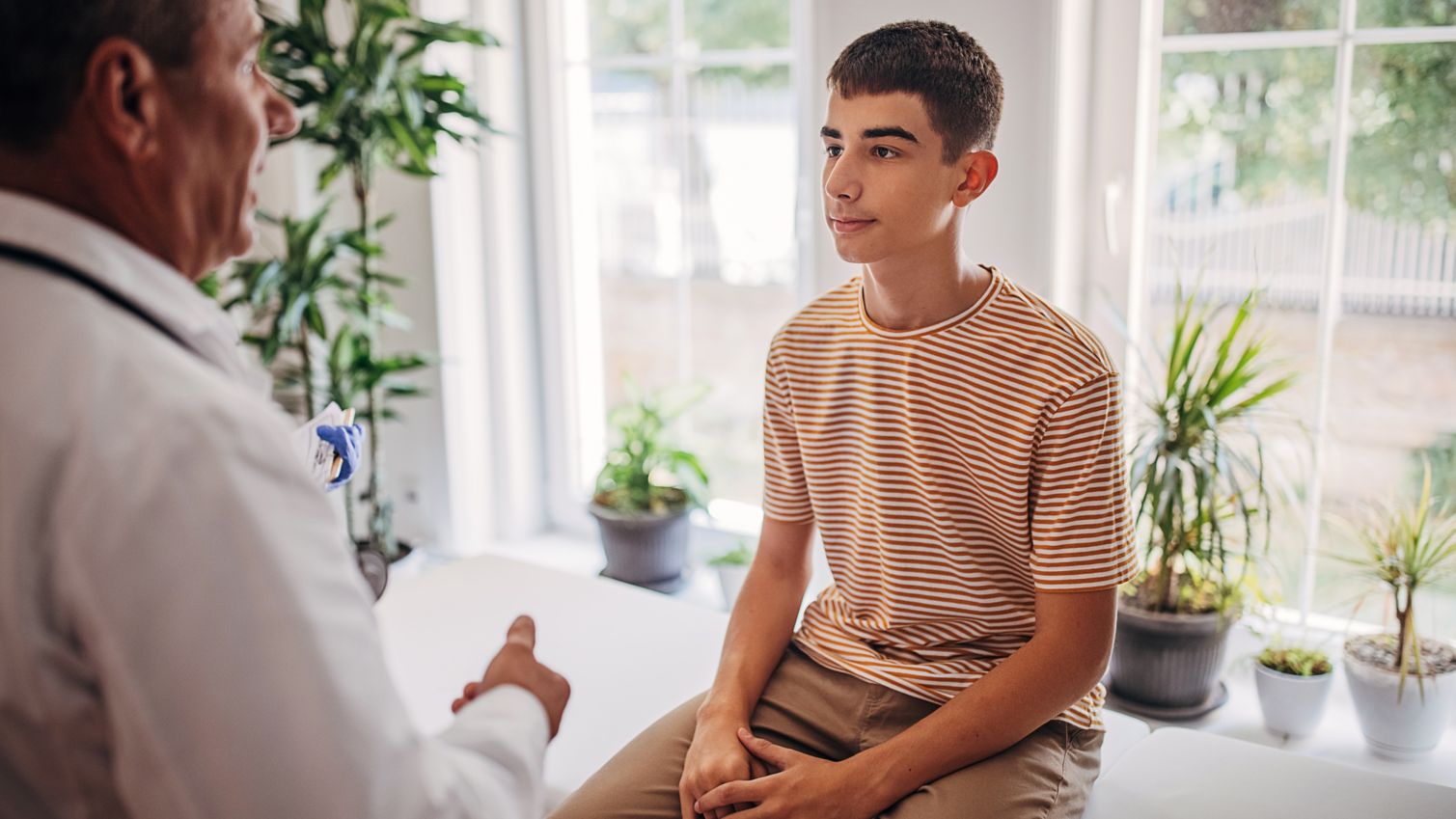 A teenage boy talks with a healthcare professional
