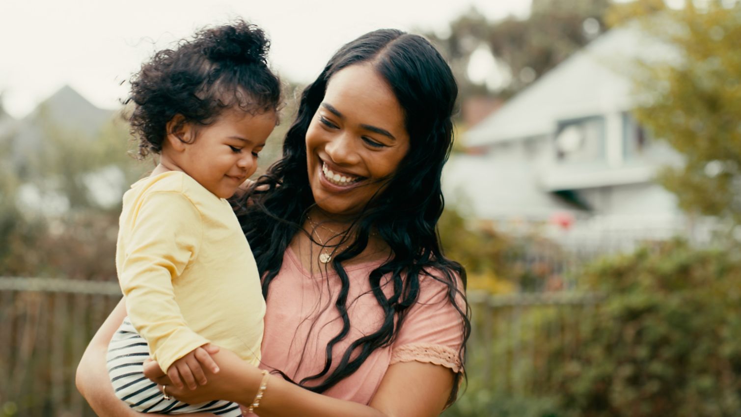 Mother holding child outside smiling