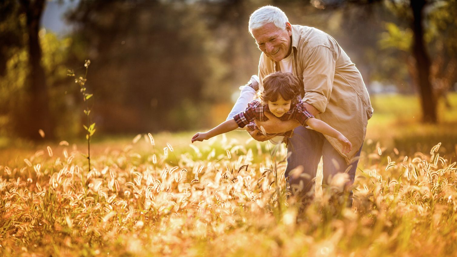 Grandfather plays with grandson outside