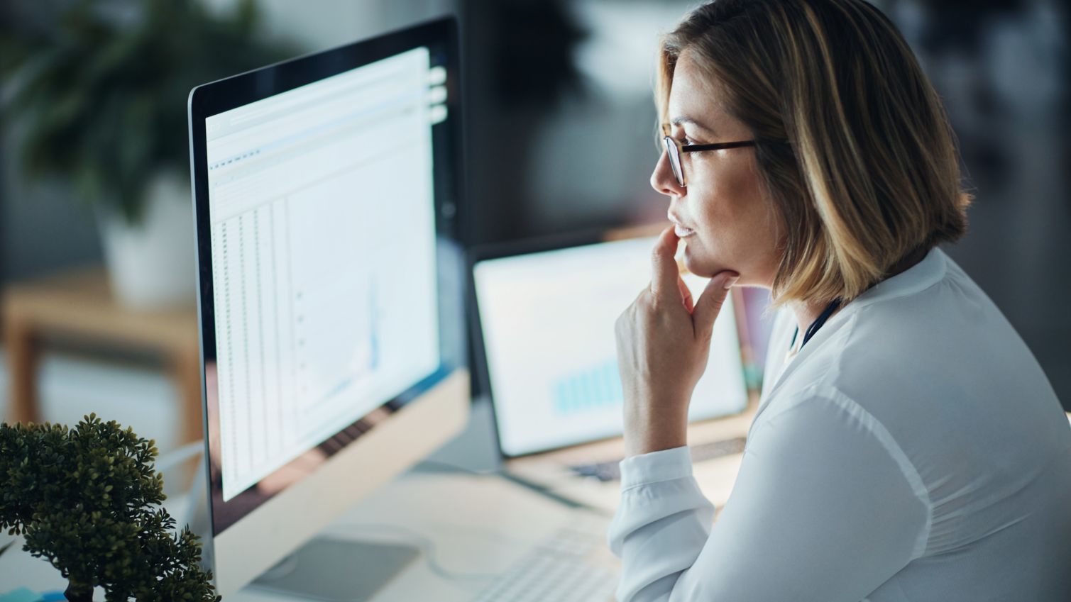 A female healthcare professional looking closely at information on a computer