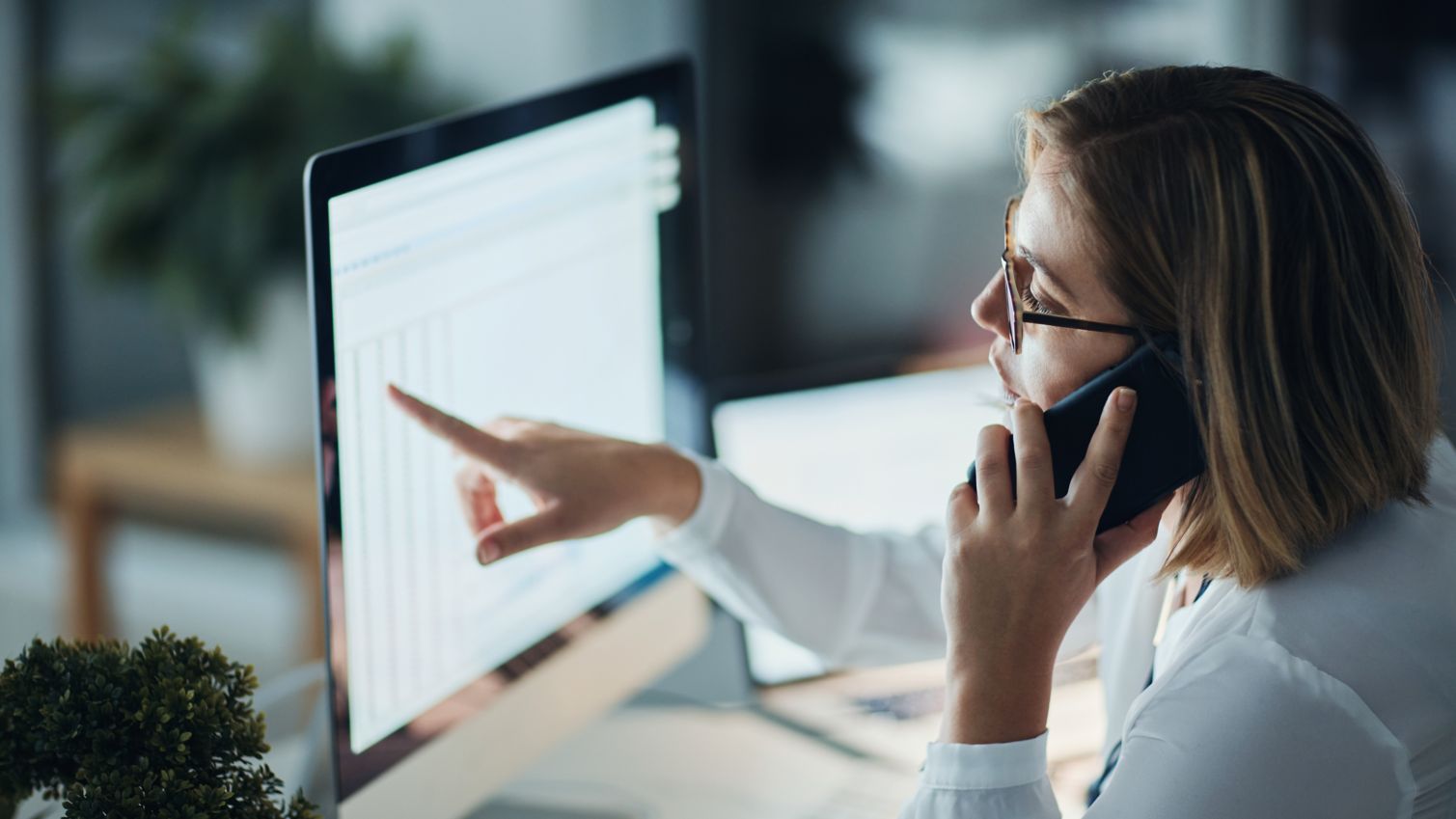 A female healthcare professional looking closely at information on a computer