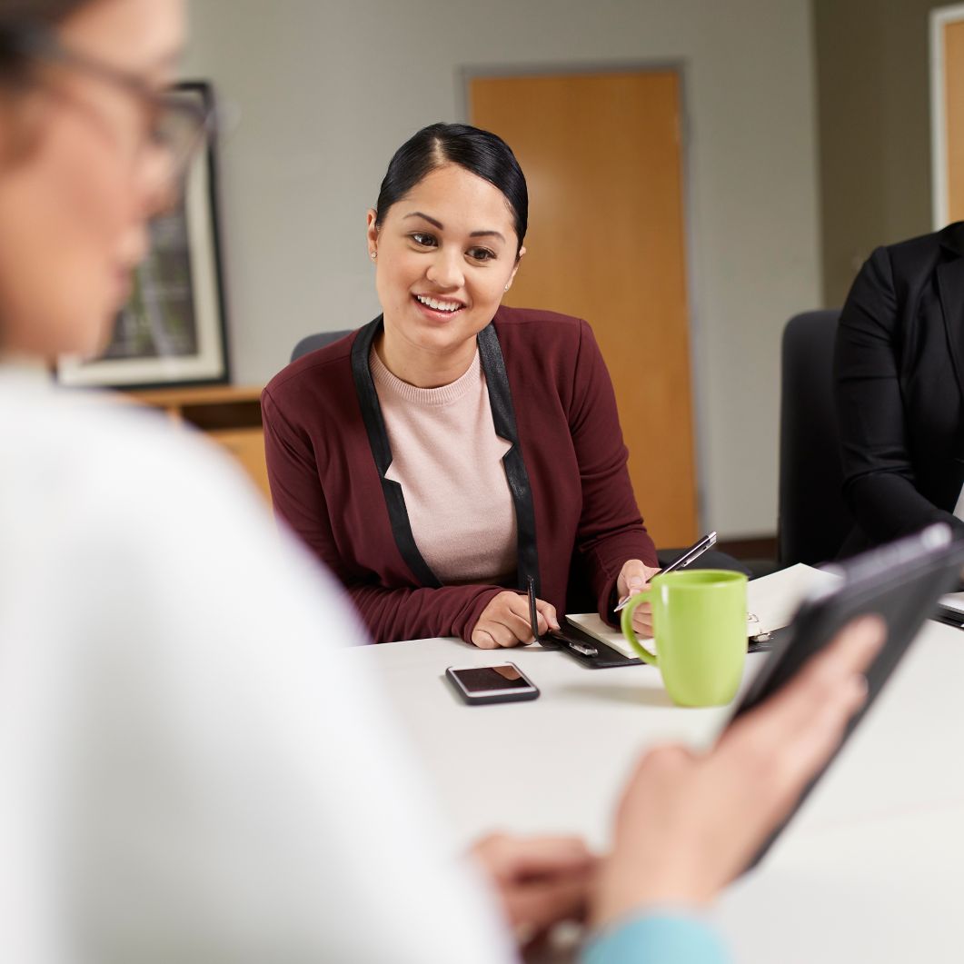 A physician shows a colleague her tablet