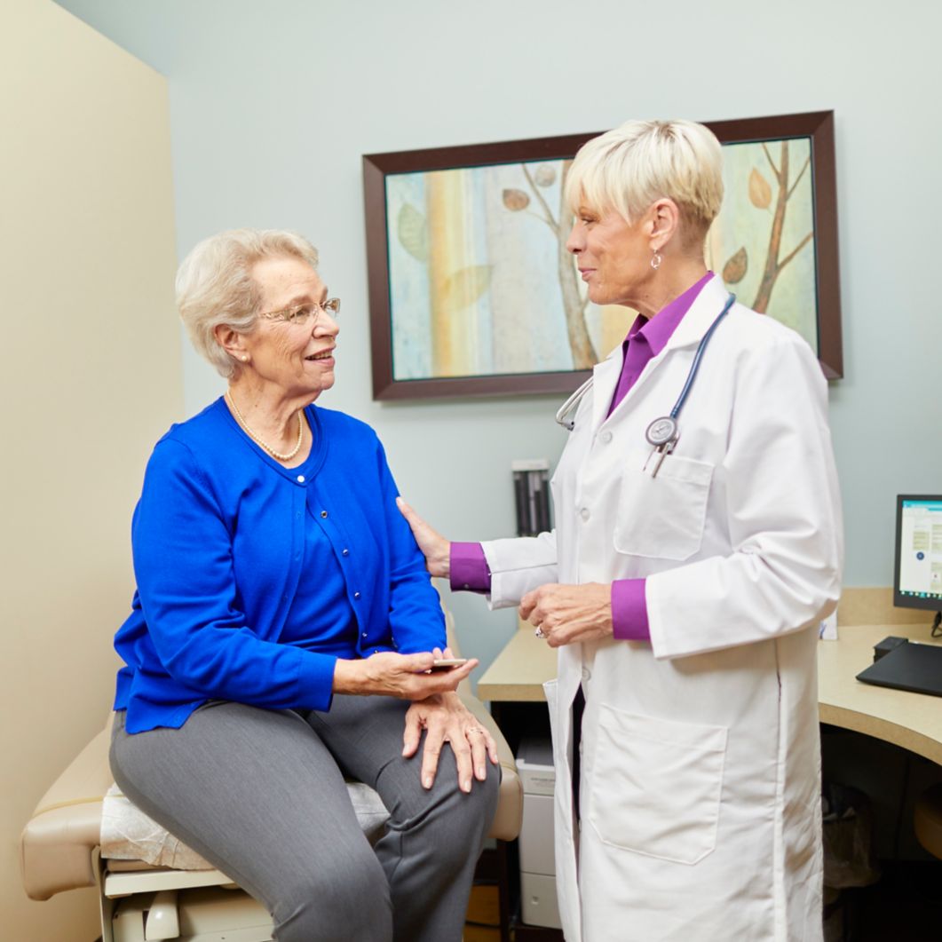 A physician consults with an older woman