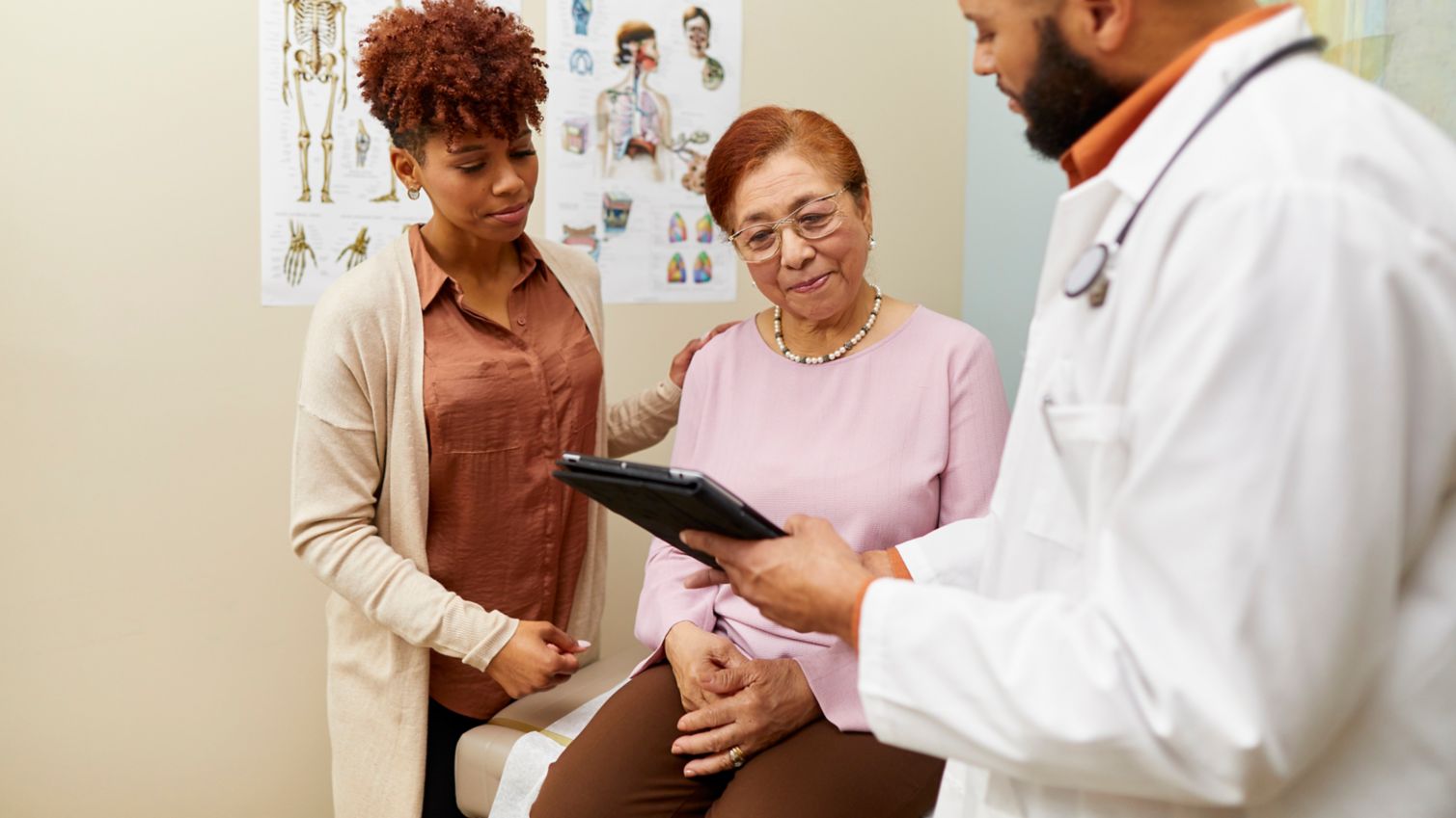 A physician explains medical information to a woman and her caregiver.