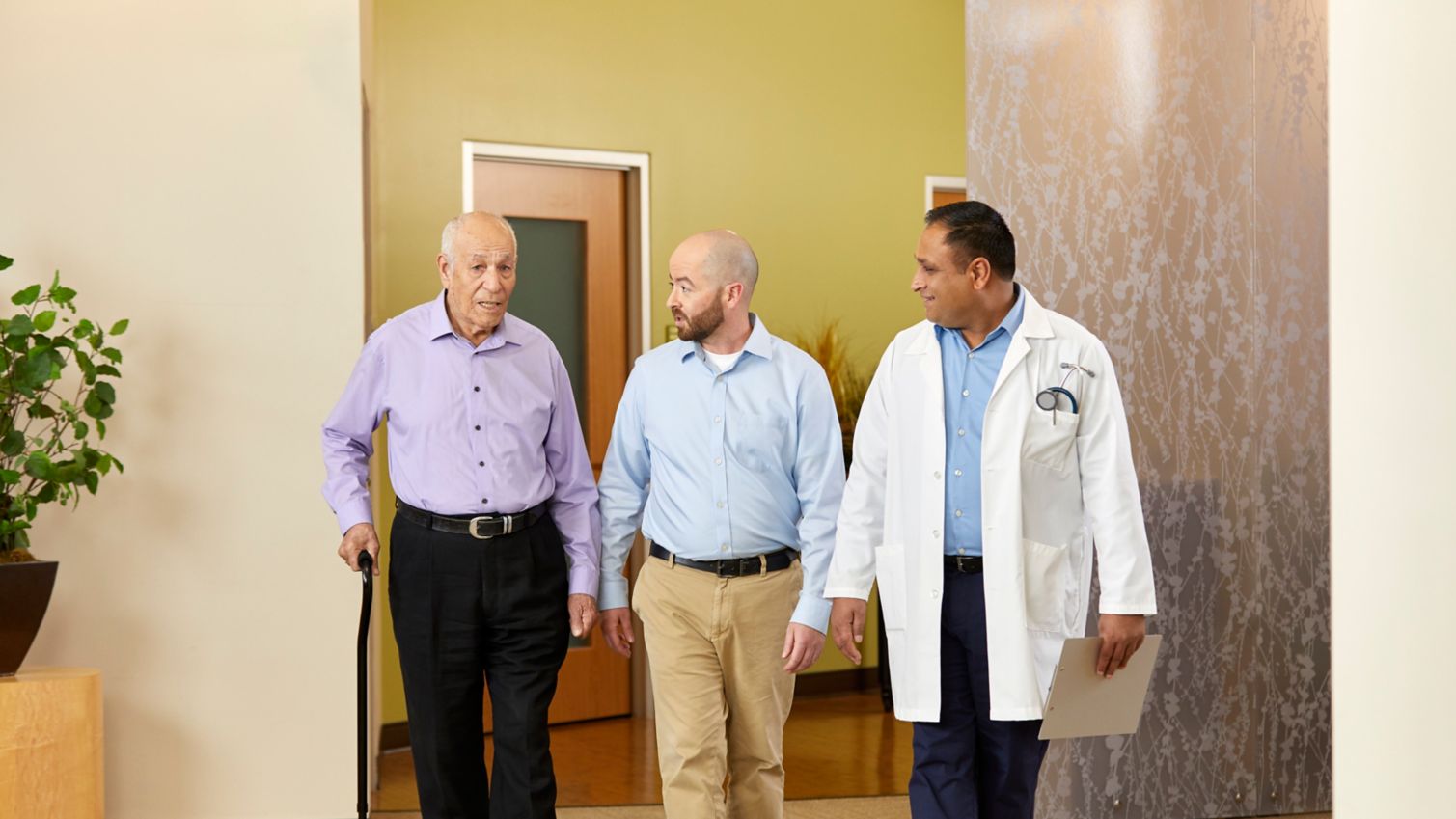 A physician consults with an elderly patient and his son