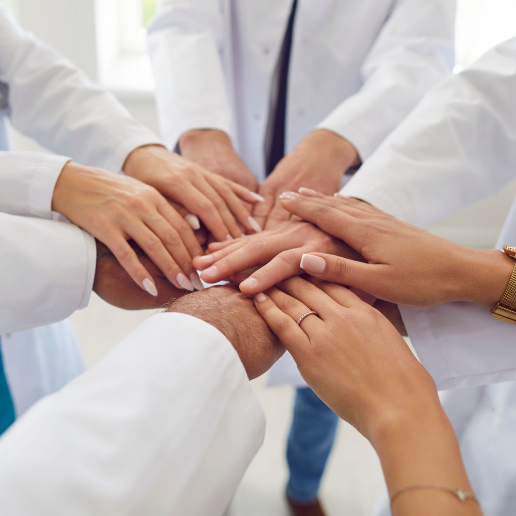 Doctors with their hands together in celebration