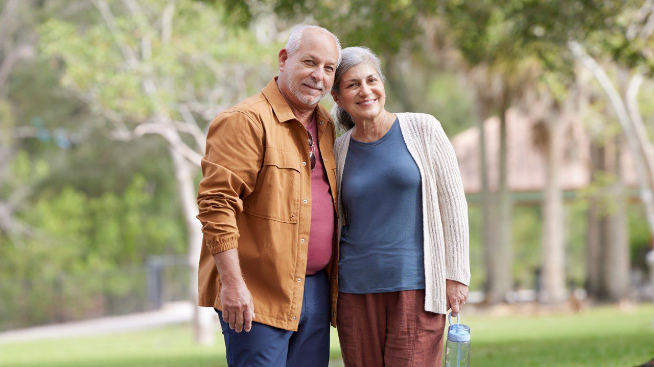 Older couple walking arm in arm outside