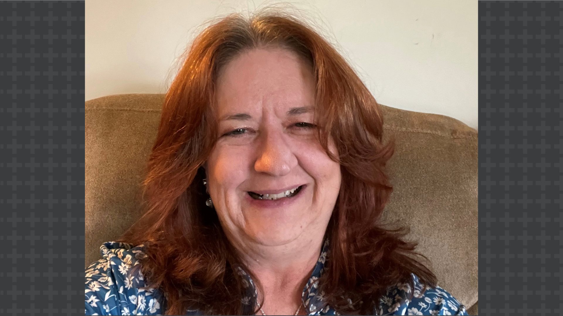 Woman with auburn shoulder length hair smiling into camera