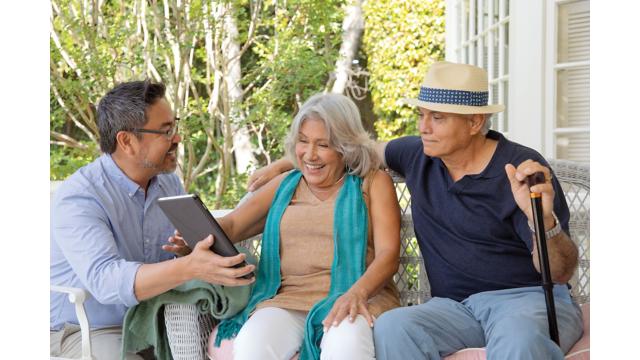 A couple meets with a Humana agent on their porch at home. 