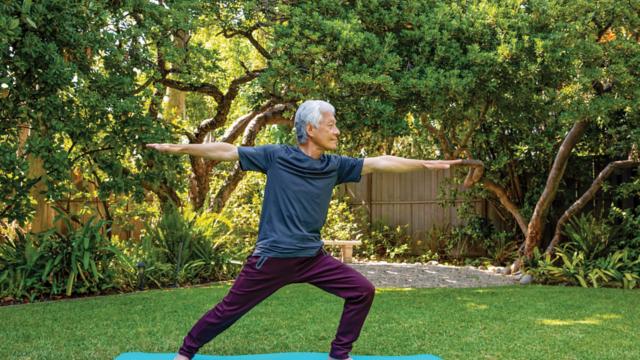 A man practices yoga outdoors.