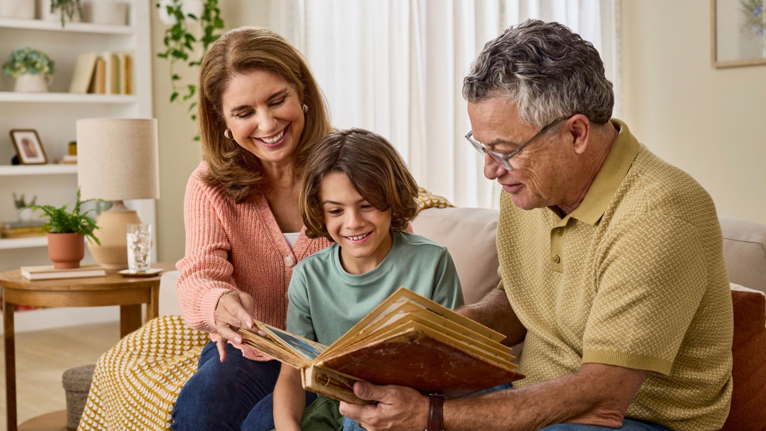 Man and woman reading a book with a boy.