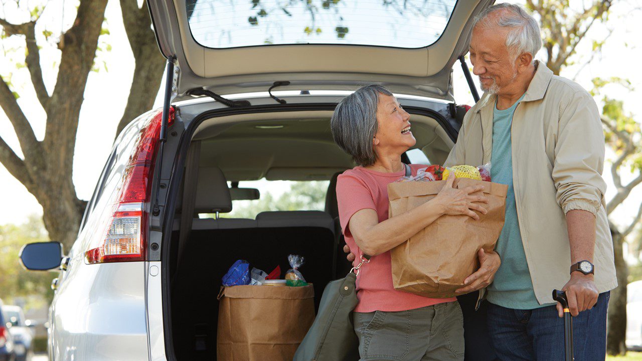 Man and woman getting groceries from vehicle