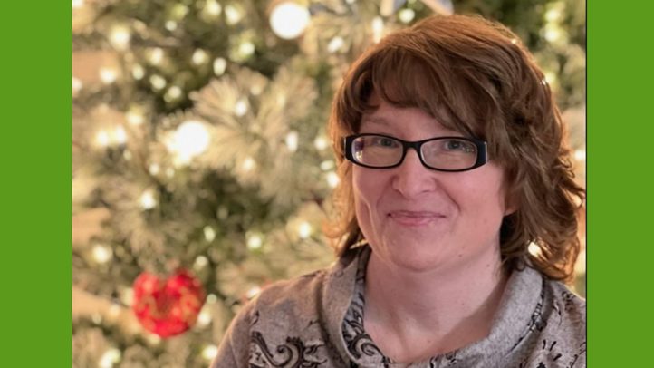 Woman smiling in front of tree