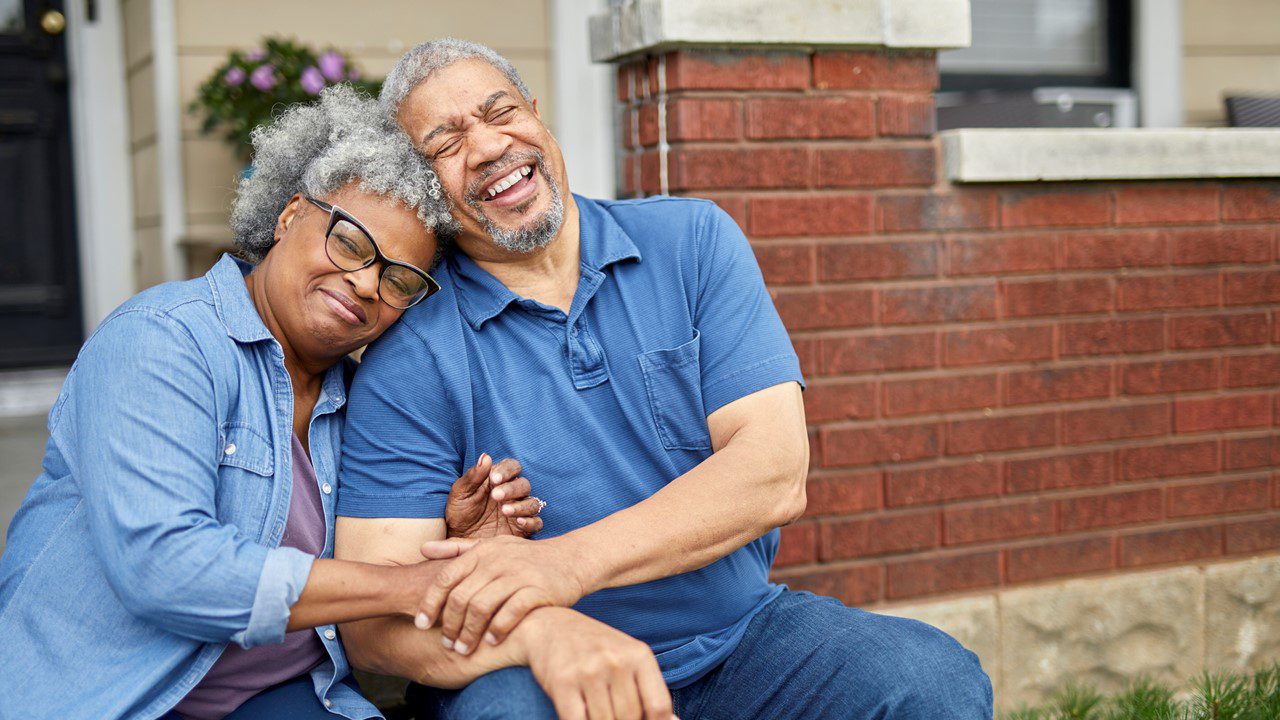 Couple sitting in front of house