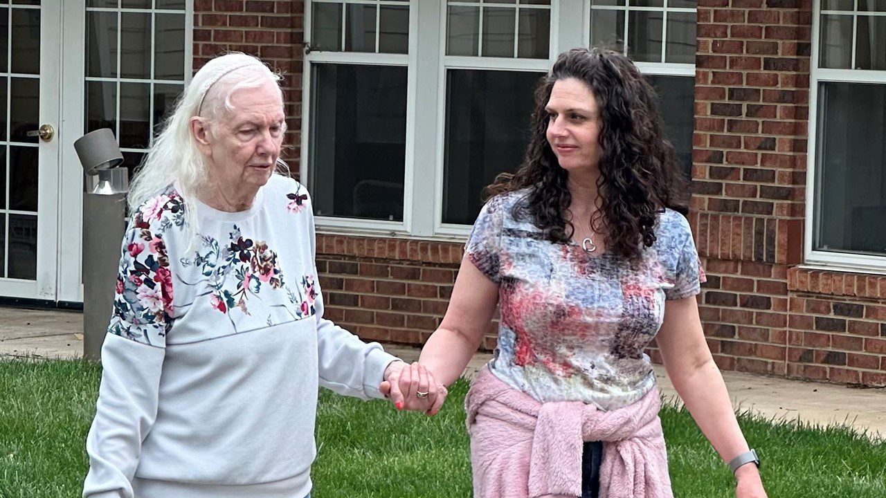 Mother and daughter walking together holding hands