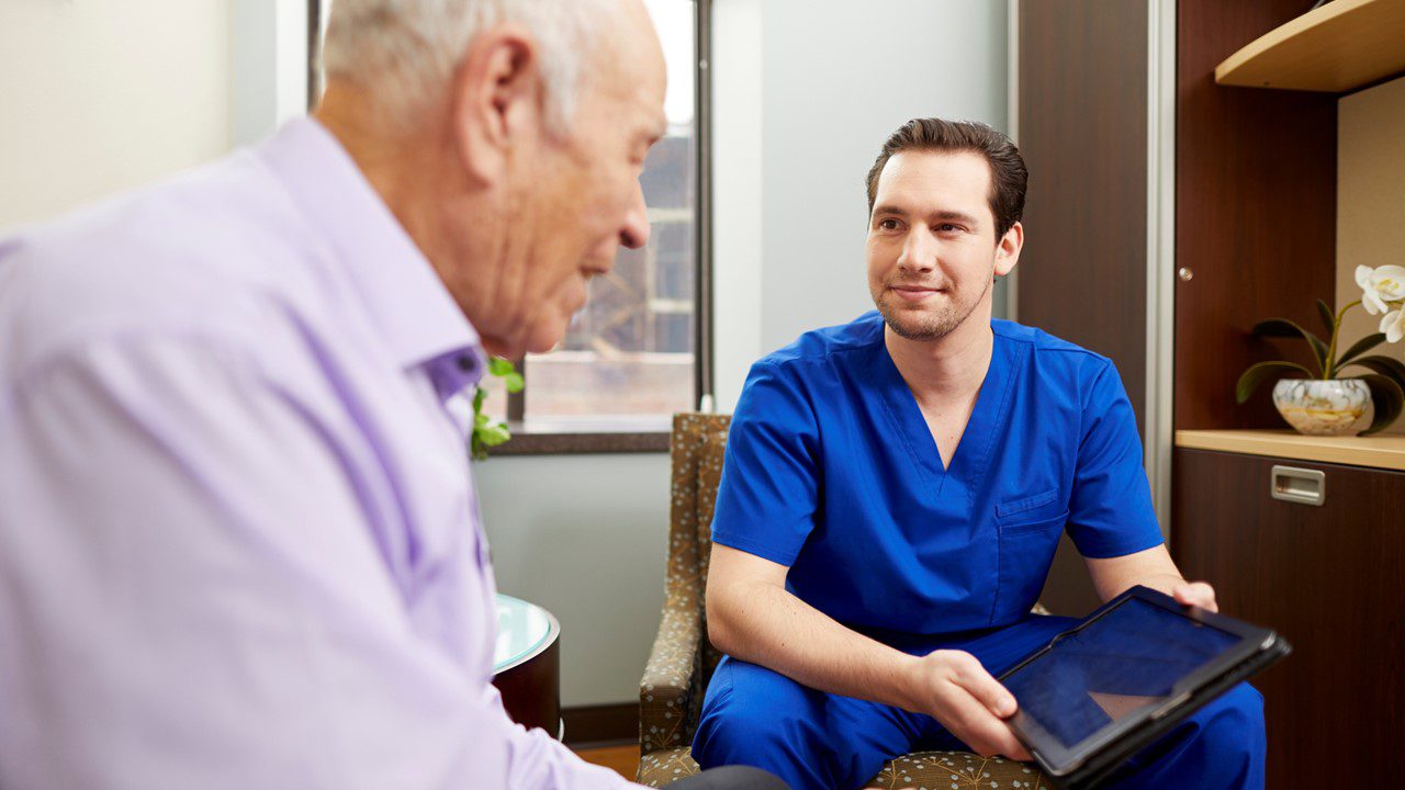 Older man in a medical office speaking with a healthcare provider