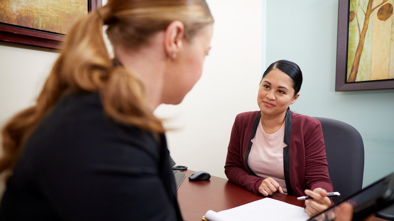 Two woman sitting across a desk