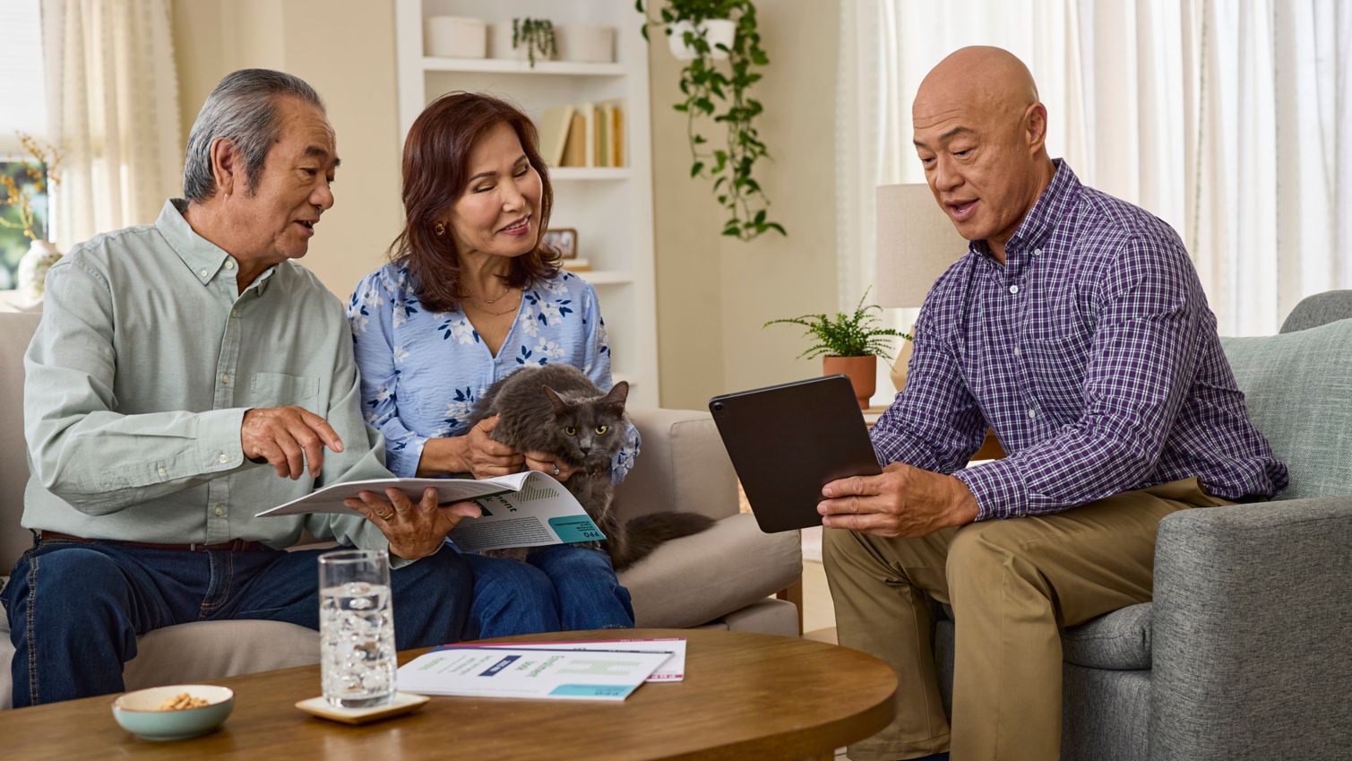 A couple meets with an agent in their living room.