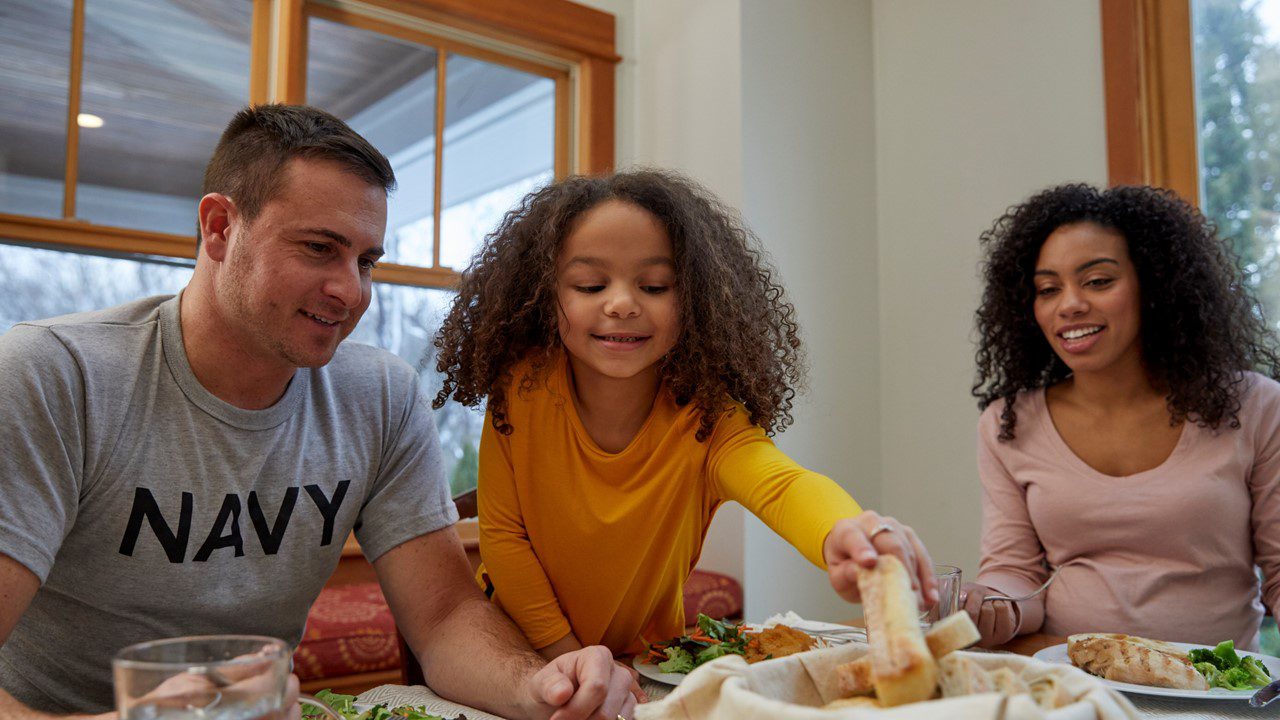 Family at dinner table with military spouse