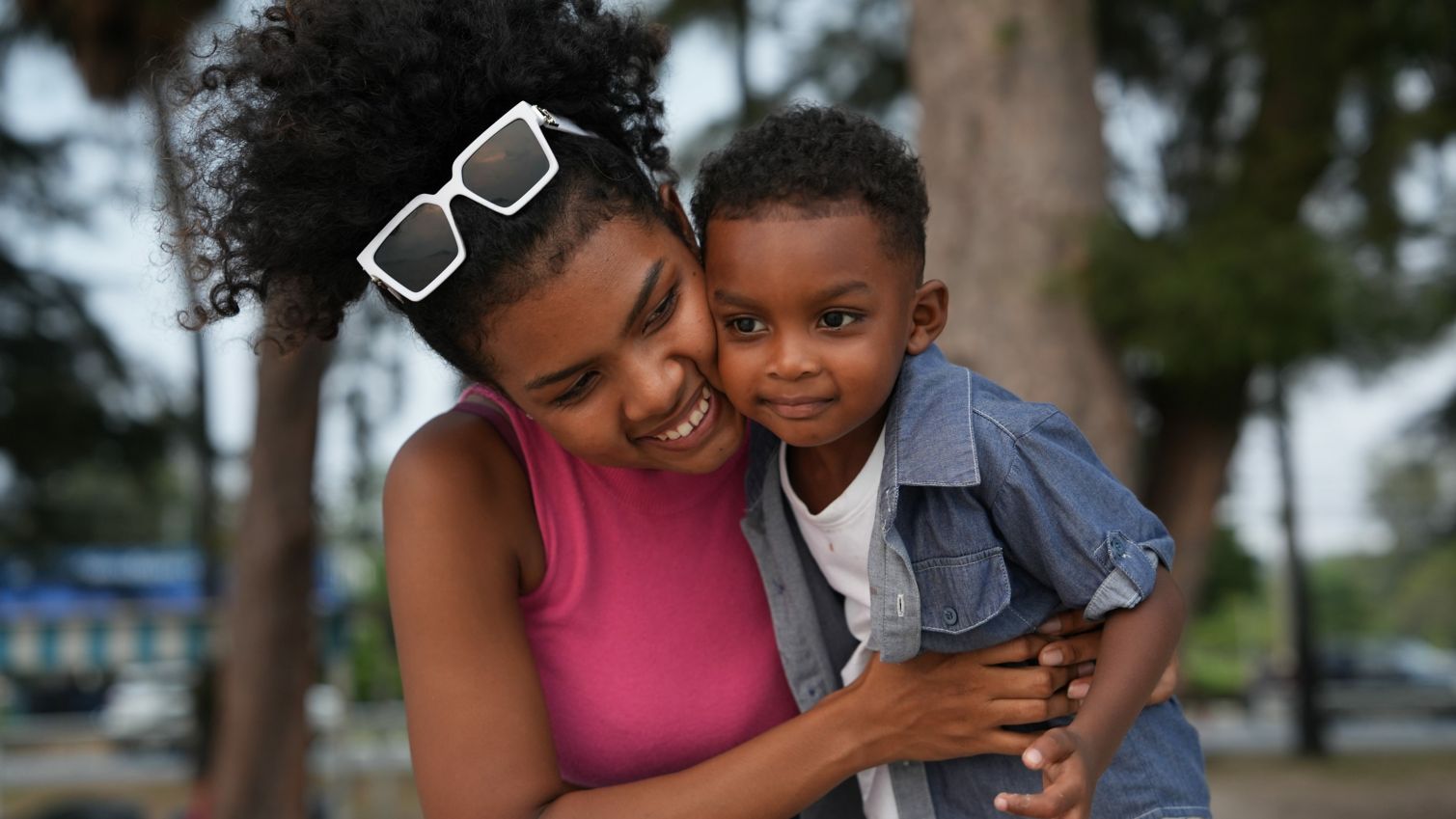 A mom hugs her son while they play outside. 