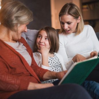 A woman and girl looking at a book together