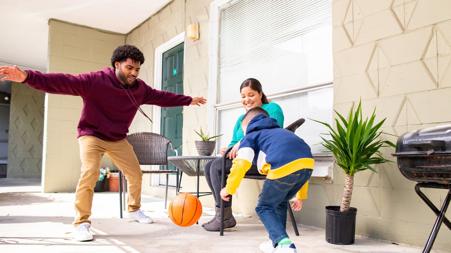 Family plays with a ball on outside porch