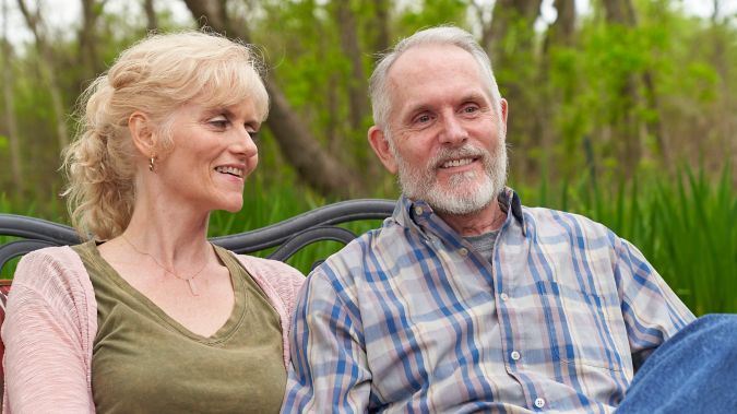 A couple sit on their porch