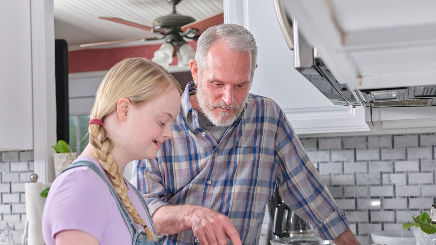 Teen daughter cooks with caregiver