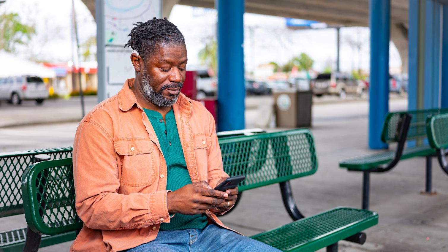 Medicaid member uses phone on city bench
